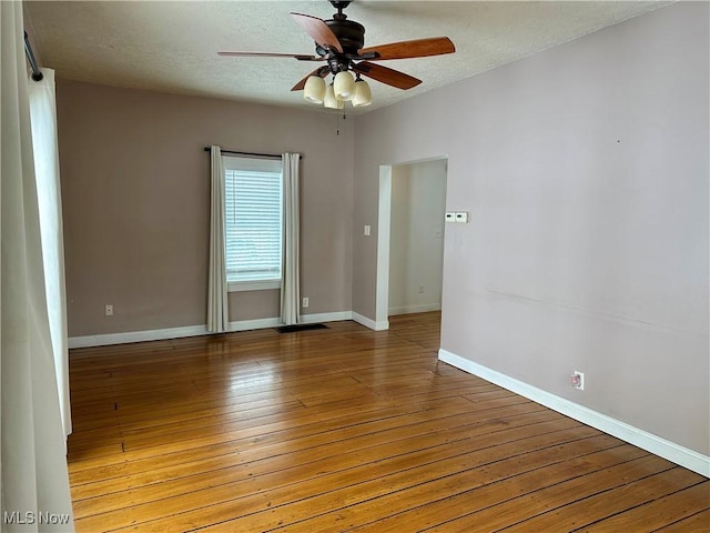 spare room with ceiling fan, light hardwood / wood-style floors, and a textured ceiling