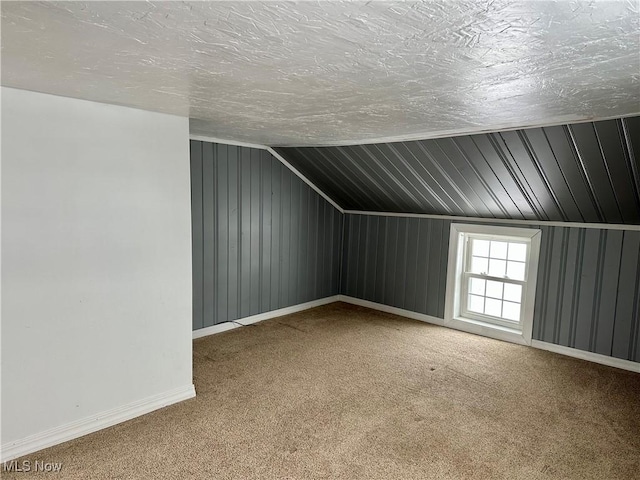 bonus room featuring a textured ceiling, carpet floors, and vaulted ceiling