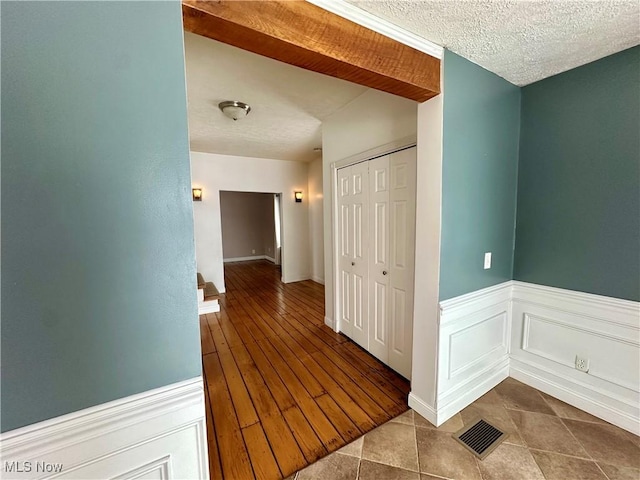 hall featuring tile patterned flooring and a textured ceiling