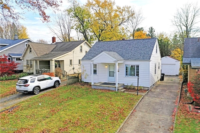 view of front of property featuring a front lawn, a garage, and an outdoor structure