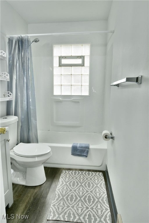 bathroom featuring wood-type flooring, toilet, and shower / tub combo