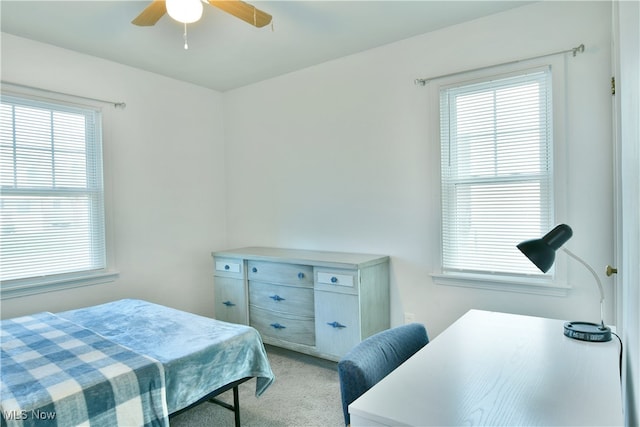 carpeted bedroom with multiple windows and ceiling fan