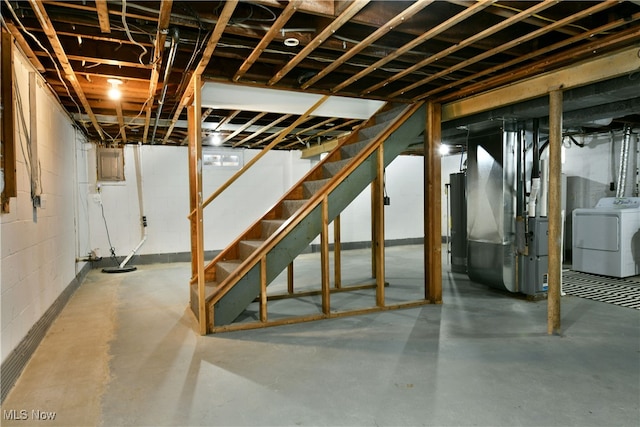 basement featuring water heater, washer / dryer, and heating unit