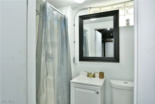 bathroom with toilet, vanity, and curtained shower