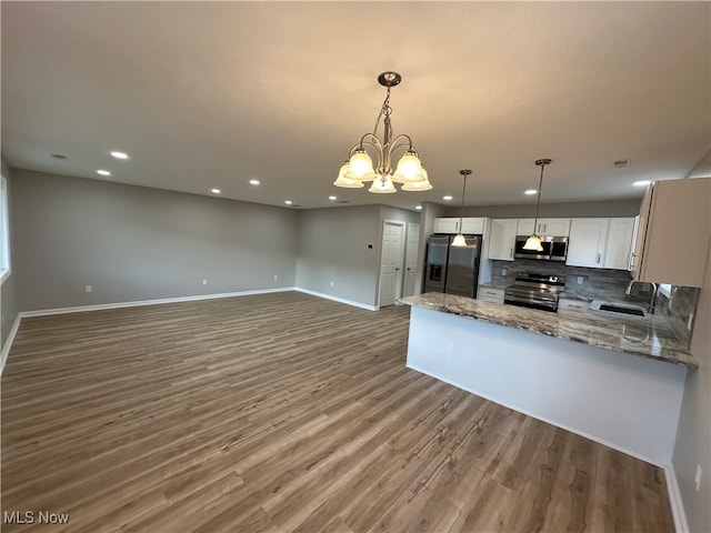 kitchen with stainless steel appliances, white cabinetry, wood-type flooring, pendant lighting, and decorative backsplash