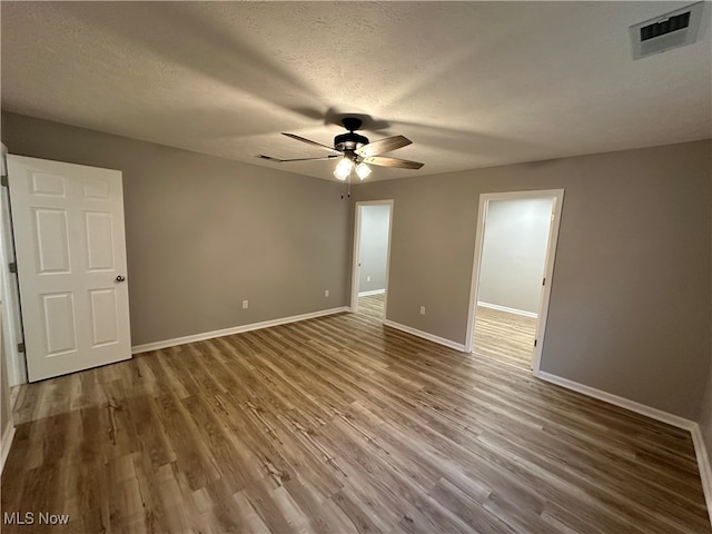 unfurnished bedroom featuring a textured ceiling, wood-type flooring, and ceiling fan