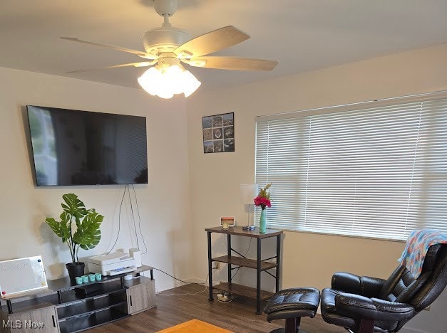 sitting room featuring dark wood-type flooring and ceiling fan