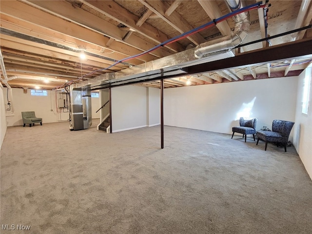 basement featuring heating unit and carpet