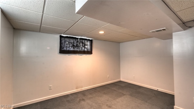 basement with carpet and a paneled ceiling