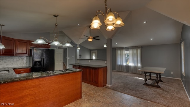 kitchen featuring black refrigerator with ice dispenser, dark stone counters, ceiling fan with notable chandelier, hanging light fixtures, and lofted ceiling