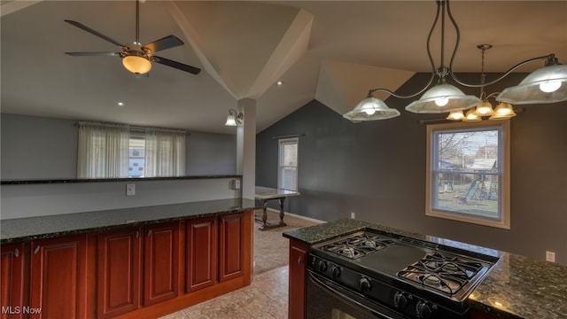 kitchen featuring dark stone counters, vaulted ceiling, black range, and ceiling fan with notable chandelier