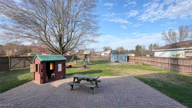 view of patio / terrace with a playground and a shed