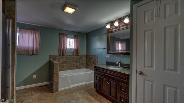 bathroom with a washtub and vanity