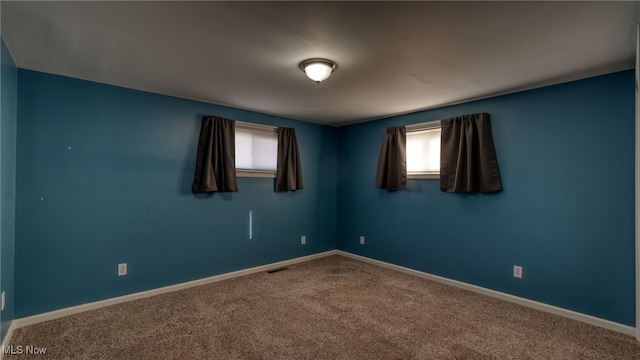 carpeted spare room featuring plenty of natural light