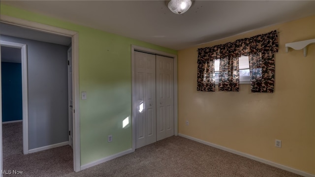 unfurnished bedroom featuring light carpet and a closet