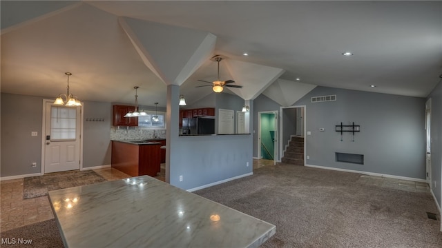 kitchen with tasteful backsplash, black fridge, dark carpet, lofted ceiling, and ceiling fan with notable chandelier