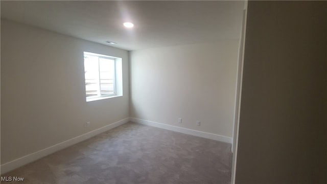 unfurnished room featuring dark colored carpet