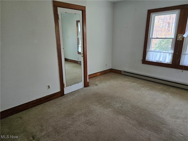 carpeted empty room with a baseboard radiator