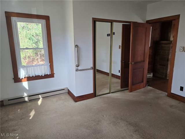 unfurnished bedroom with baseboard heating and light colored carpet