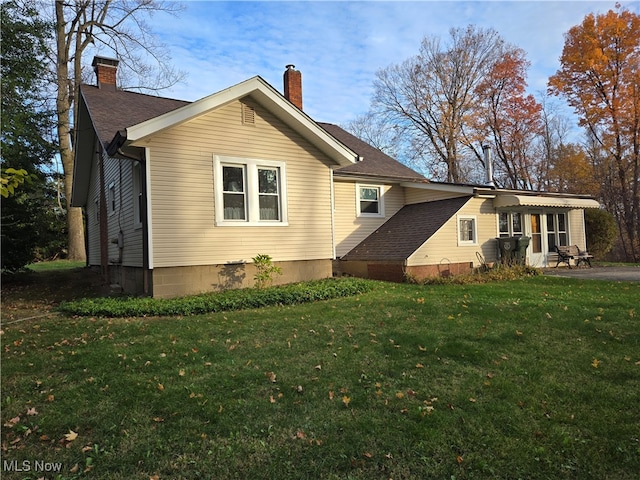 rear view of property with a lawn