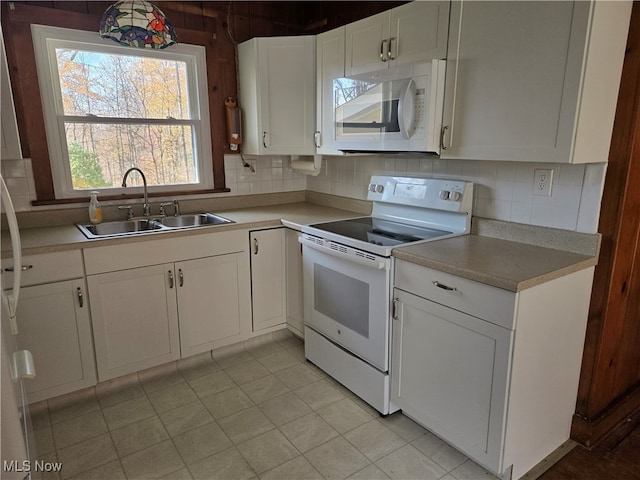 kitchen with white cabinetry, sink, white appliances, and backsplash