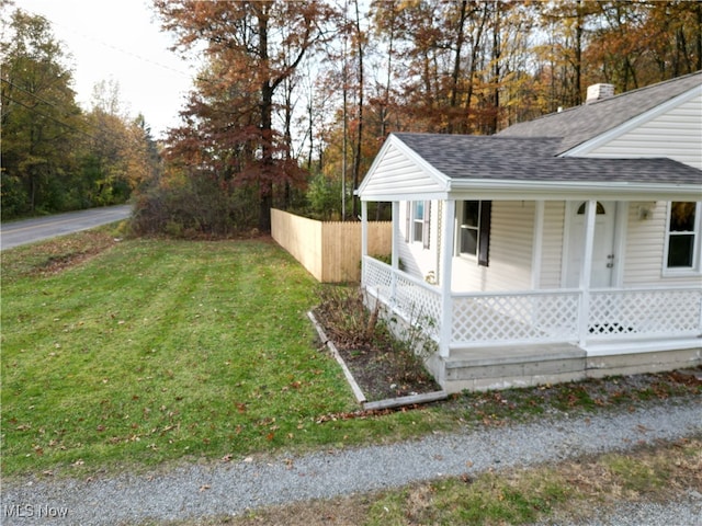 view of home's exterior with a yard and a porch