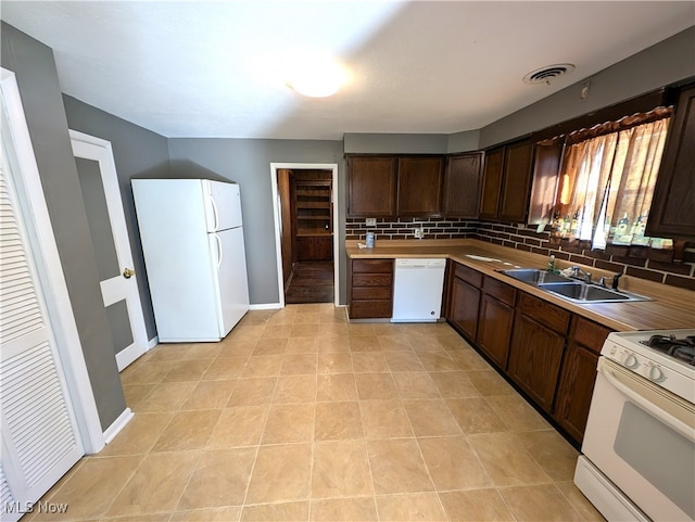 kitchen with tasteful backsplash, white appliances, sink, and dark brown cabinets