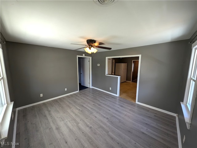 unfurnished room with light wood-type flooring and ceiling fan