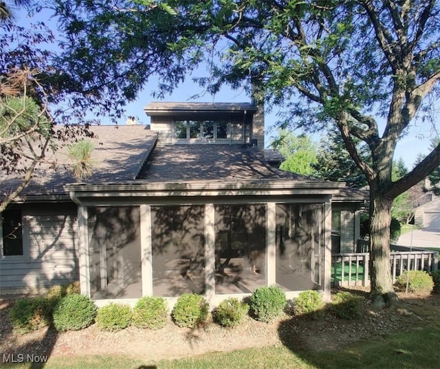 back of property with a sunroom