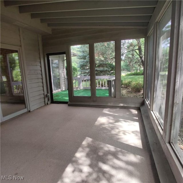 unfurnished sunroom with beam ceiling