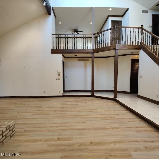 interior space featuring beamed ceiling, ceiling fan, high vaulted ceiling, and light hardwood / wood-style floors