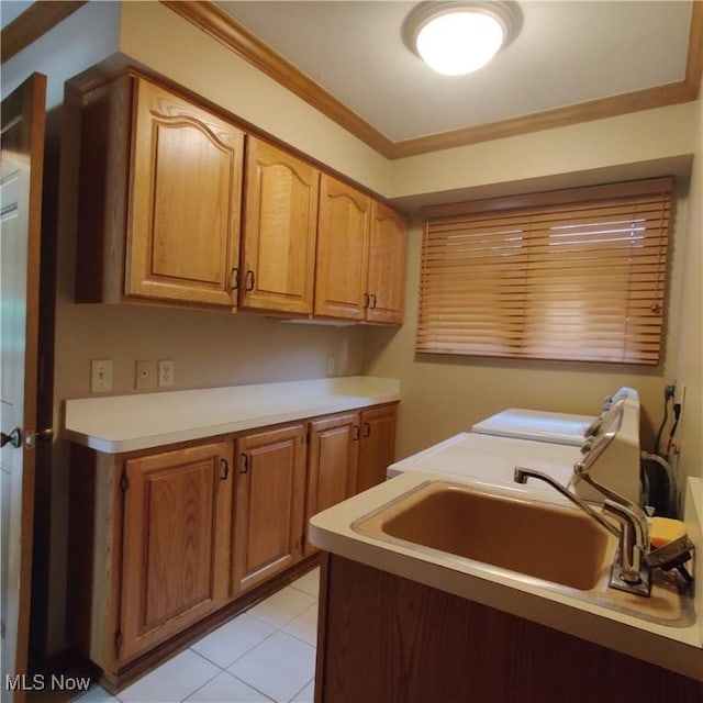 kitchen featuring separate washer and dryer, sink, light tile patterned floors, and ornamental molding