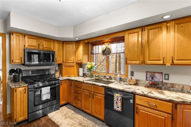 370 Wilcox Rd, Austintown, OH 44515 - kitchen featuring stainless steel appliances, a sink, light stone countertops, brown cabinetry, and dark wood finished floors
