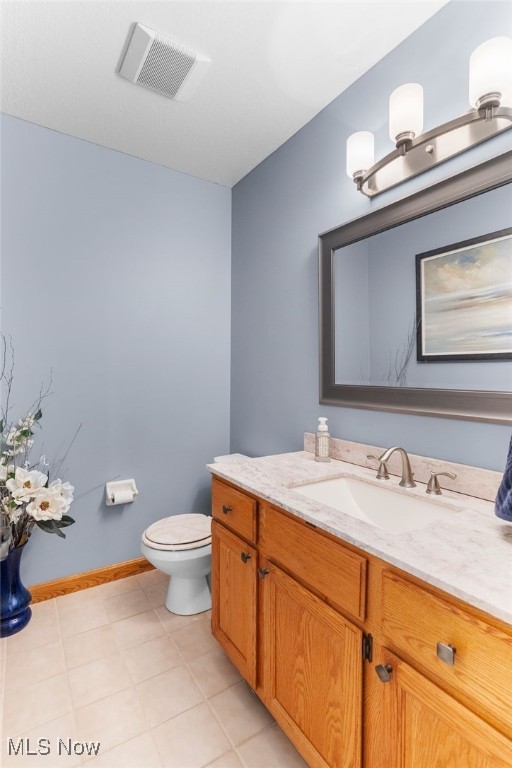 bathroom featuring vanity, tile patterned floors, and toilet