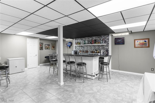 bar featuring white cabinetry, a paneled ceiling, and refrigerator