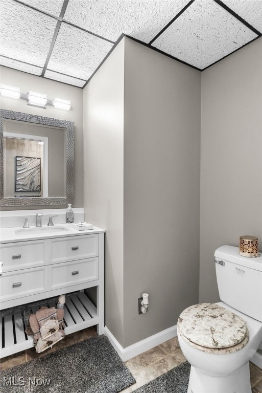 370 Wilcox Rd, Austintown, OH 44515 - bathroom featuring vanity, toilet, a paneled ceiling, and baseboards