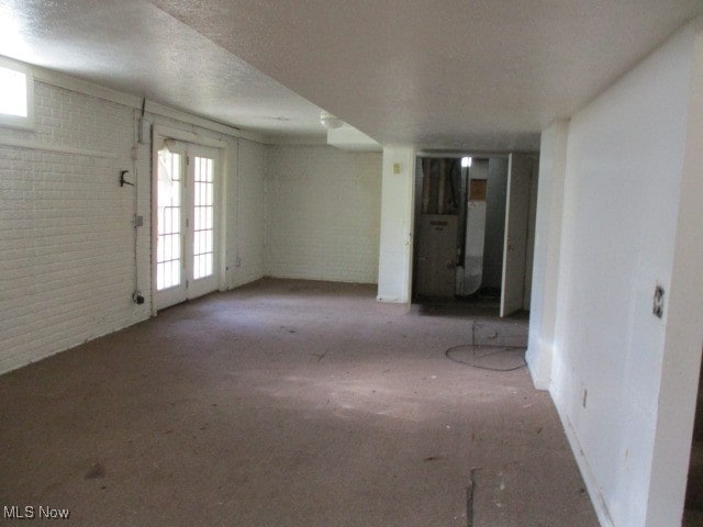 interior space with a textured ceiling and brick wall