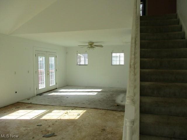 unfurnished living room featuring ceiling fan, a healthy amount of sunlight, and french doors