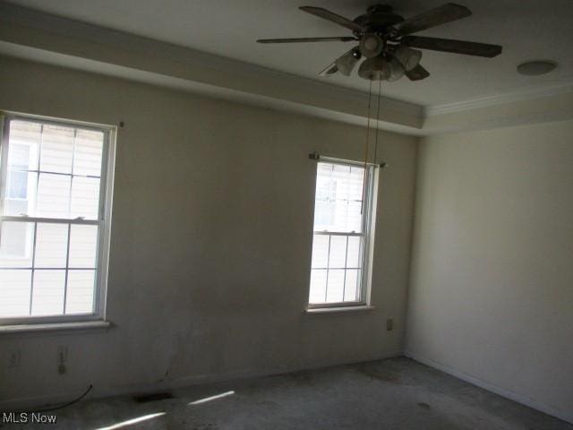 empty room with ceiling fan and a wealth of natural light