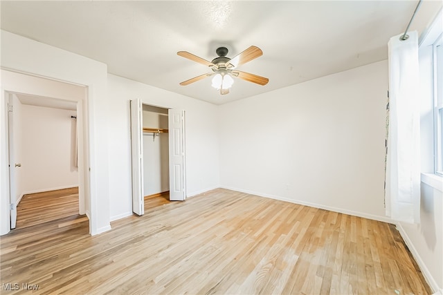 unfurnished bedroom featuring ceiling fan, a closet, and light wood-type flooring