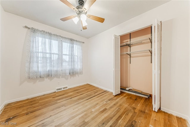 unfurnished bedroom with hardwood / wood-style flooring, ceiling fan, and a closet