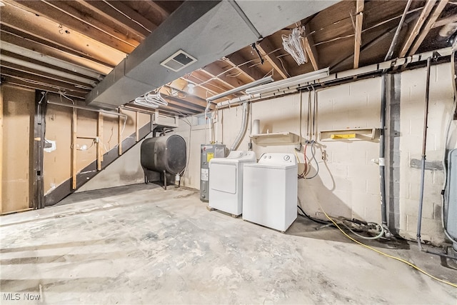 basement with electric water heater and washer and clothes dryer