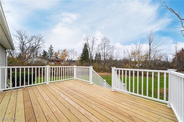 wooden deck featuring a lawn