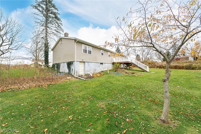 view of side of property featuring a lawn and a deck