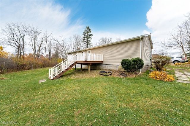 rear view of property with a wooden deck and a yard