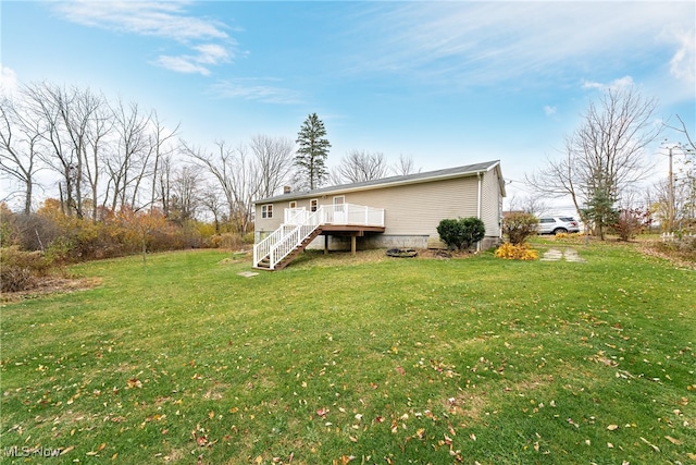 back of property with a deck and a yard