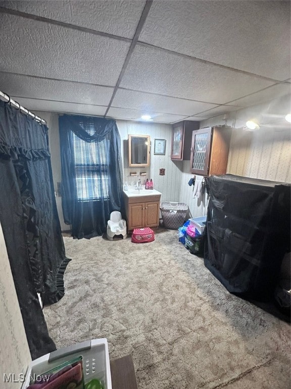 interior space featuring a paneled ceiling, sink, and carpet