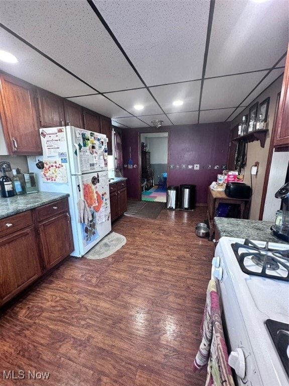 kitchen with a paneled ceiling, dark hardwood / wood-style floors, and white appliances