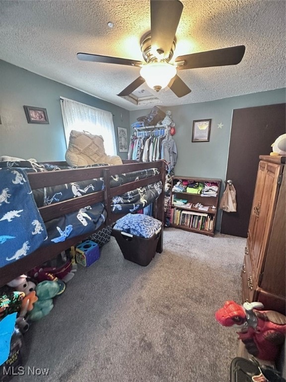 carpeted bedroom with a textured ceiling and ceiling fan