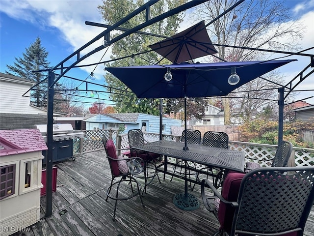 wooden terrace with an outbuilding and a grill